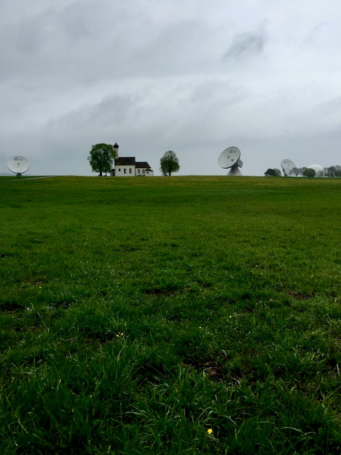 pexels-photo-2912103 Scenic countryside view with satellite dishes and a lonely house on a cloudy day.
